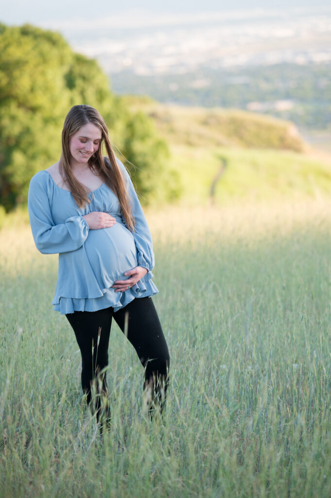 Mom-to-be standing on the mountainside of Tunnel Springs for Utah County Family Photographer