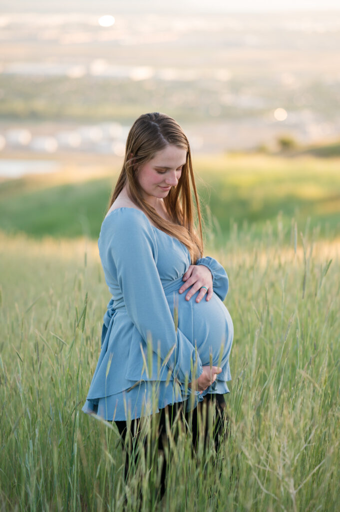 Mom looking down lovingly at pregnant belly for Utah County Family Photographer