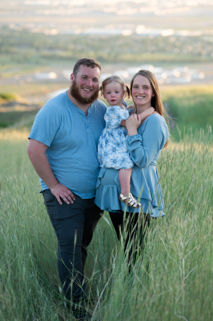 Family of three smiling at the camera at Tunnel Springs for Utah County Family Photographer
