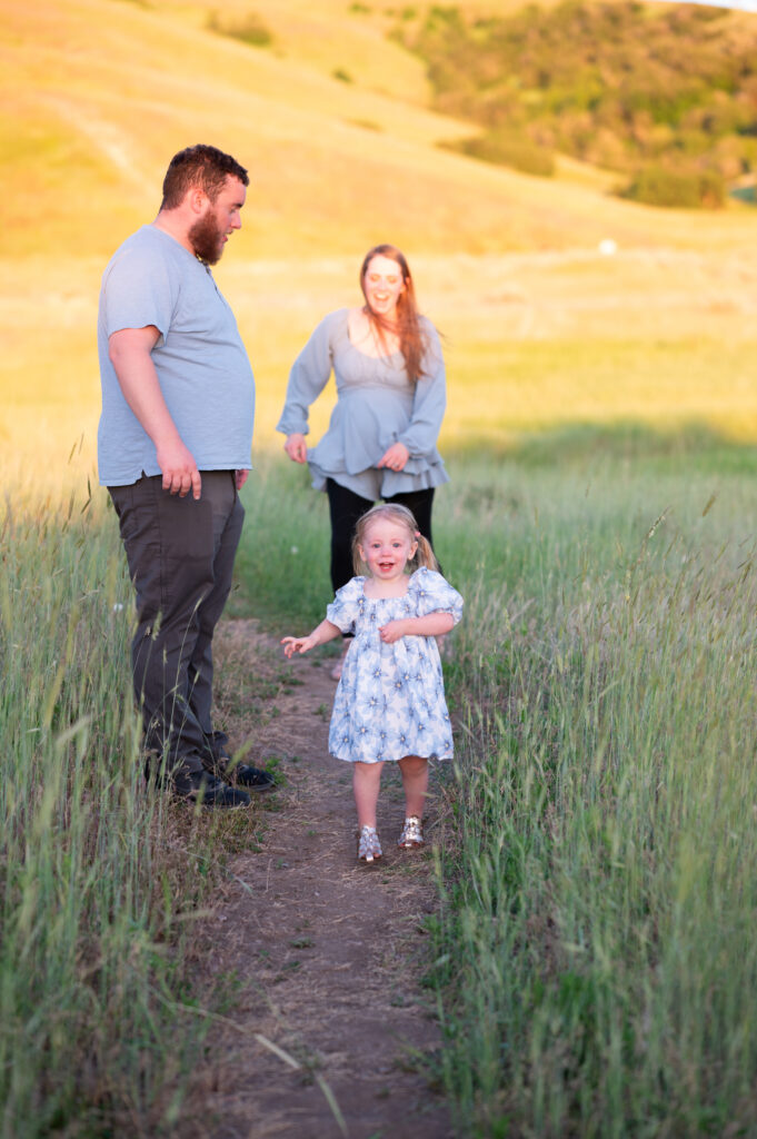 Family of three playing chase at Tunnel Springs for Utah County Family Photographer