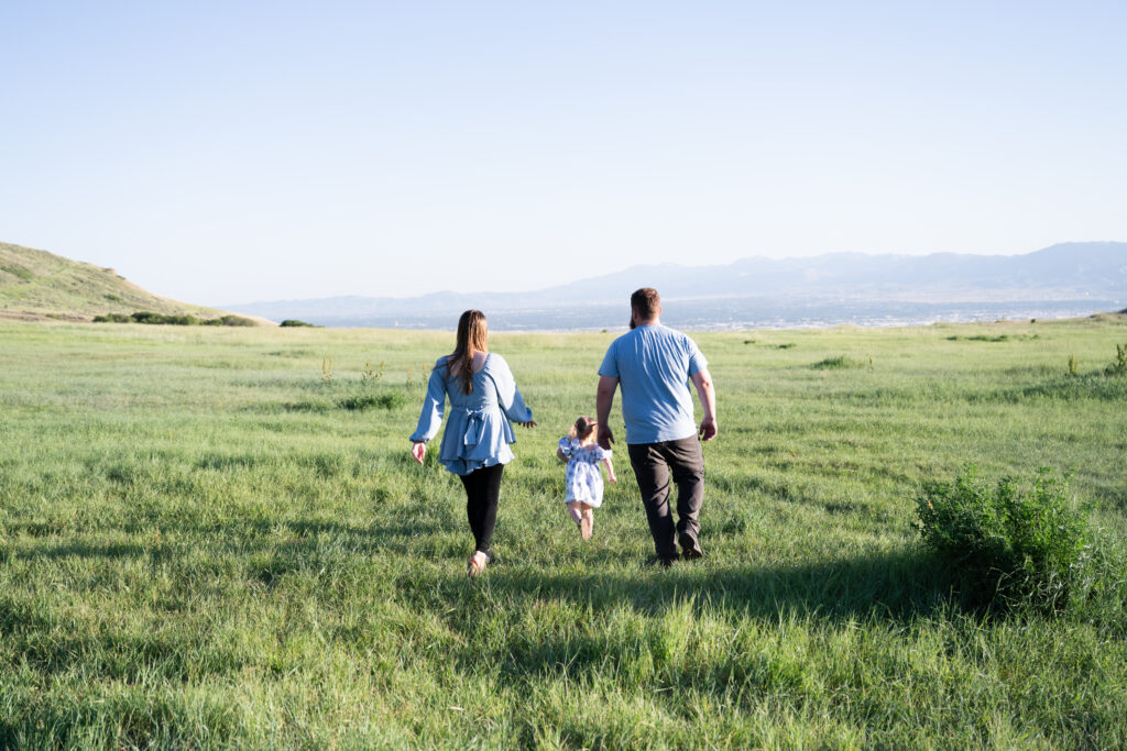 Family of three walking away from camera of Utah Family Photographer