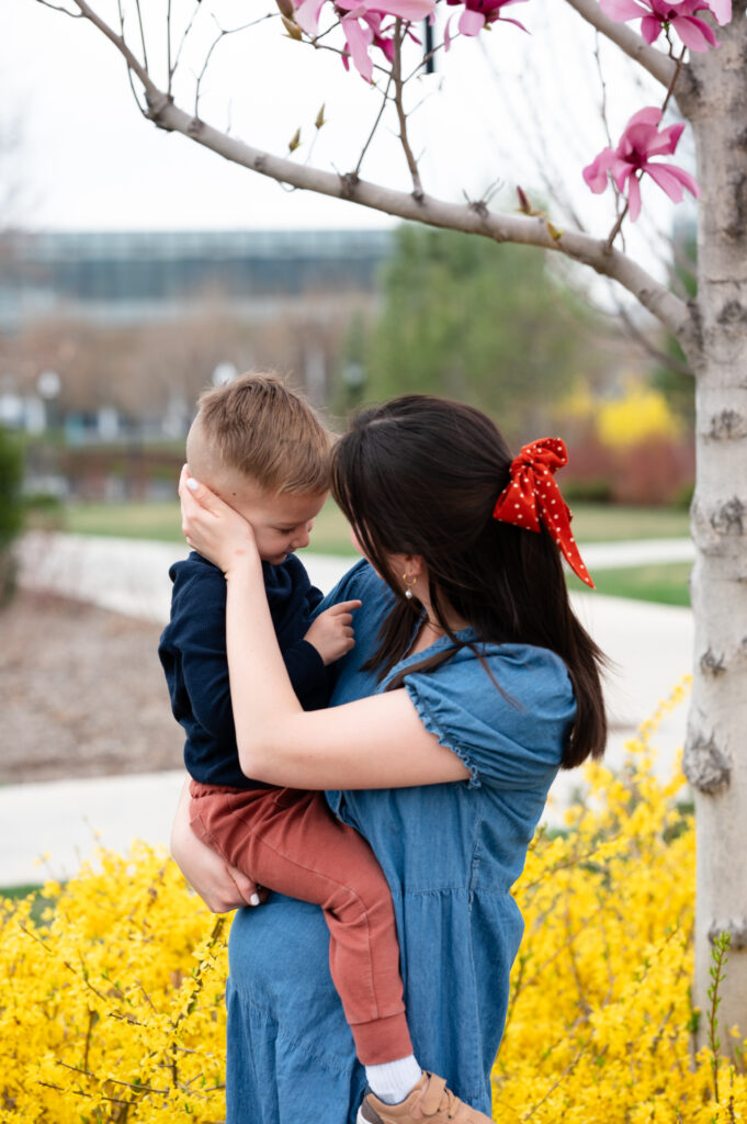 Mother and son giving "butterfly kisses" while wearing coordinating outfits for family photos