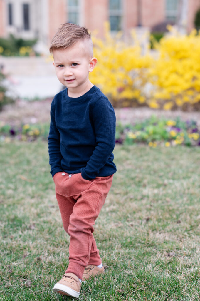 Little boy smiling for camera wearing a blue and red outfit to coordinate with his family for family photos in Salt Lake, UT