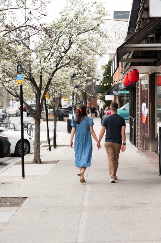 Couple walking hand-in-hand down a street away from the photographer during their Salt Lake City Family Photo Session